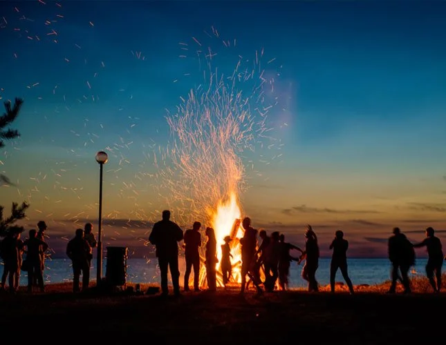 People Enjoying a Camp Fire Near the Beach