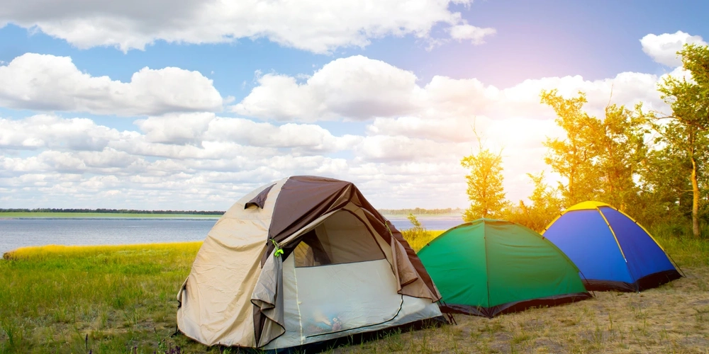 Tents pitched by campers near the water's edge during the summer season
