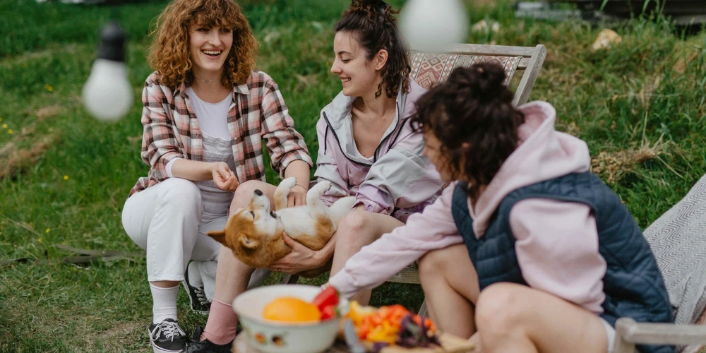 Three female campers with pet dog in campsite