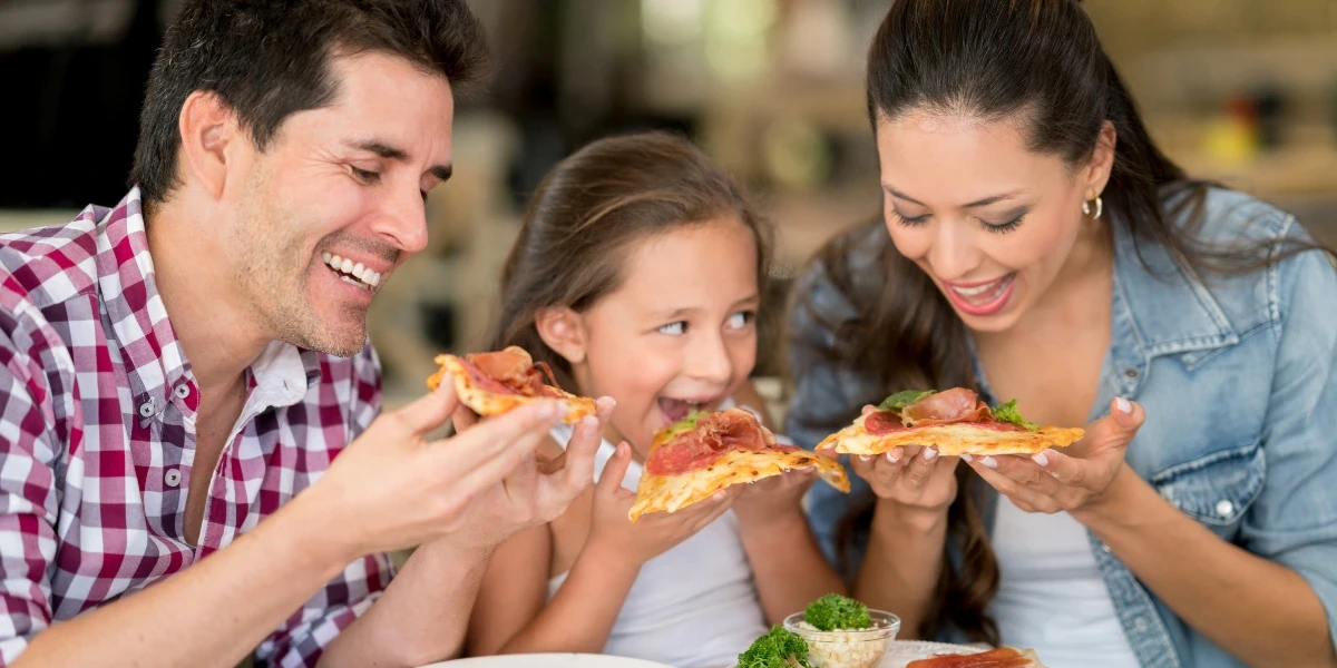 A family of three dining at a pizza place