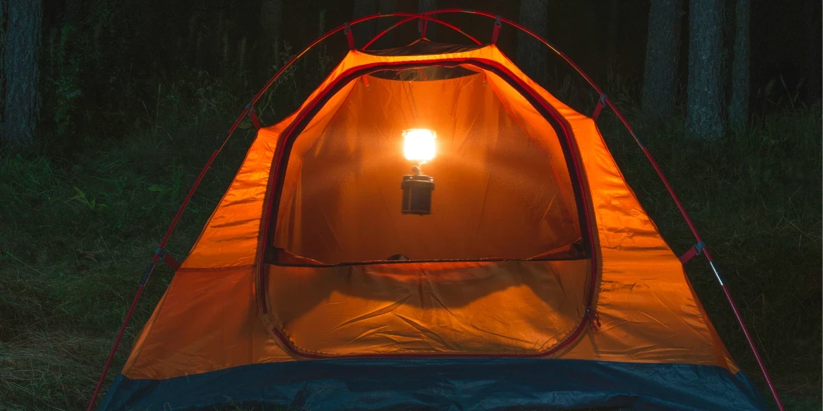 An open orange tent at night 