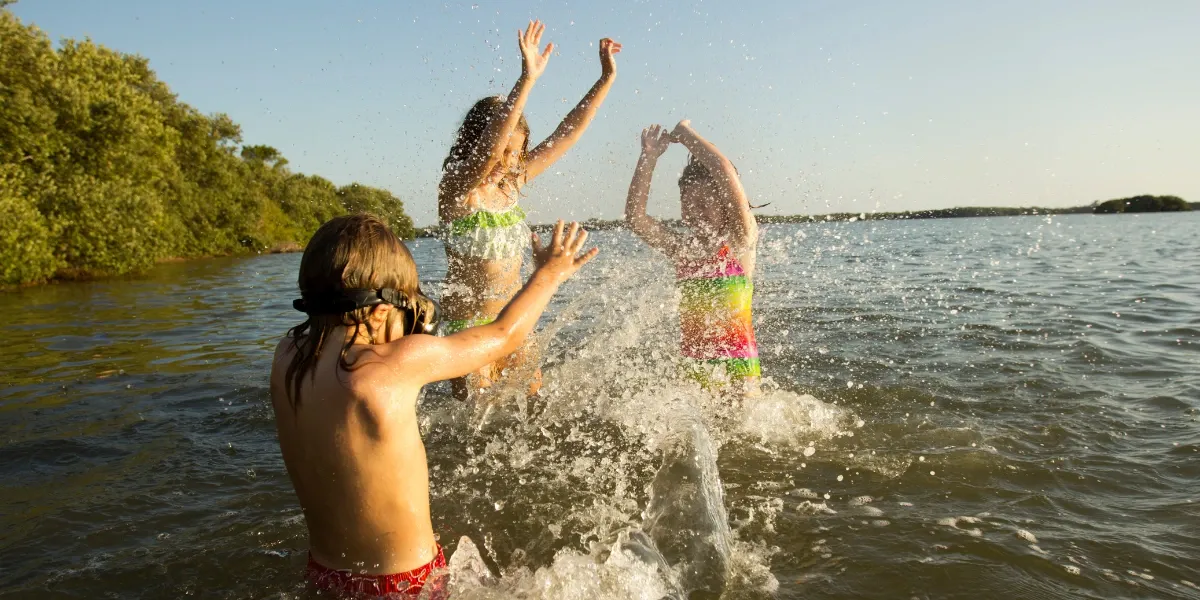 Three kids swimming in the lake