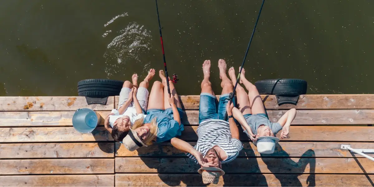 Family fishing on a jetty by the lake.