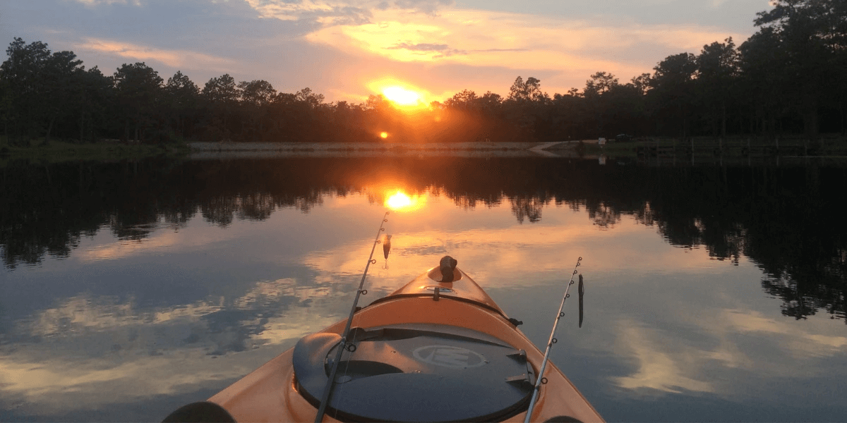 Kayak on a lake with fishing rods suspended on the front end