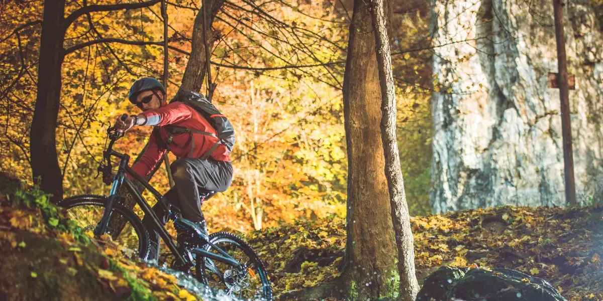 Man biking on a trail during fall