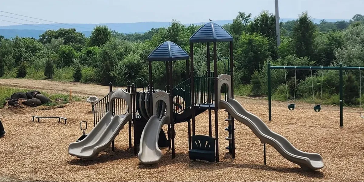 Swings and a giant slide set in Ridgeview Campground's playground area