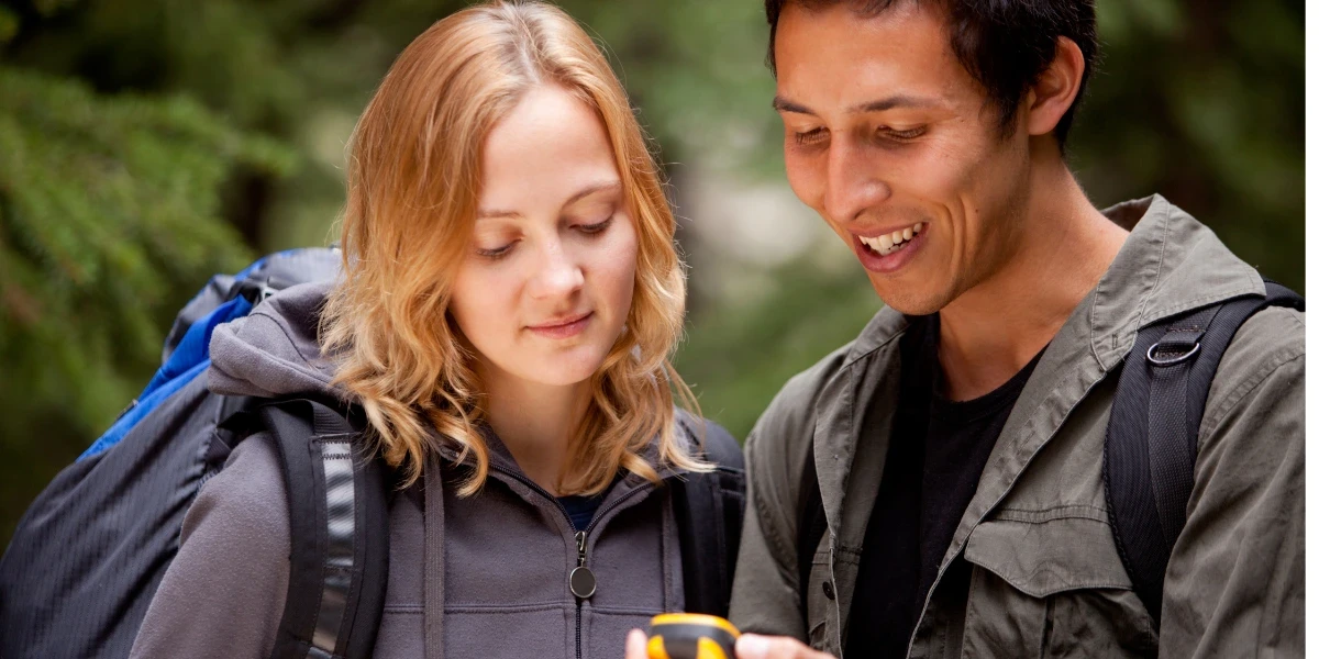 Two hikers—male and female—looking at the GPS