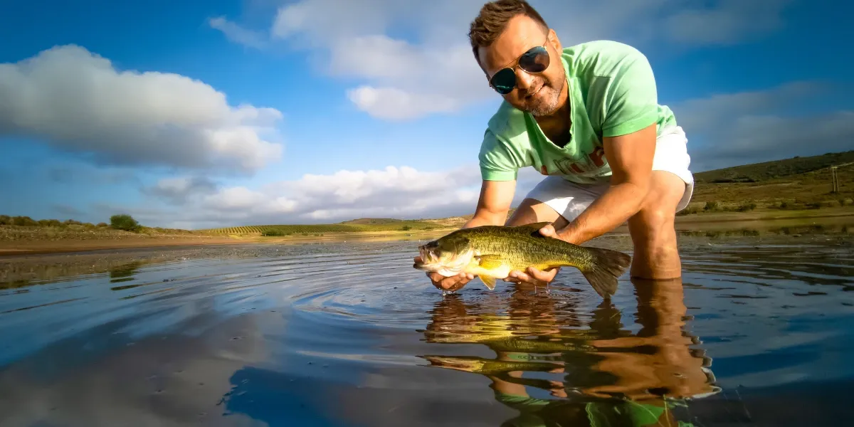 Man holding bass he caught from the lake