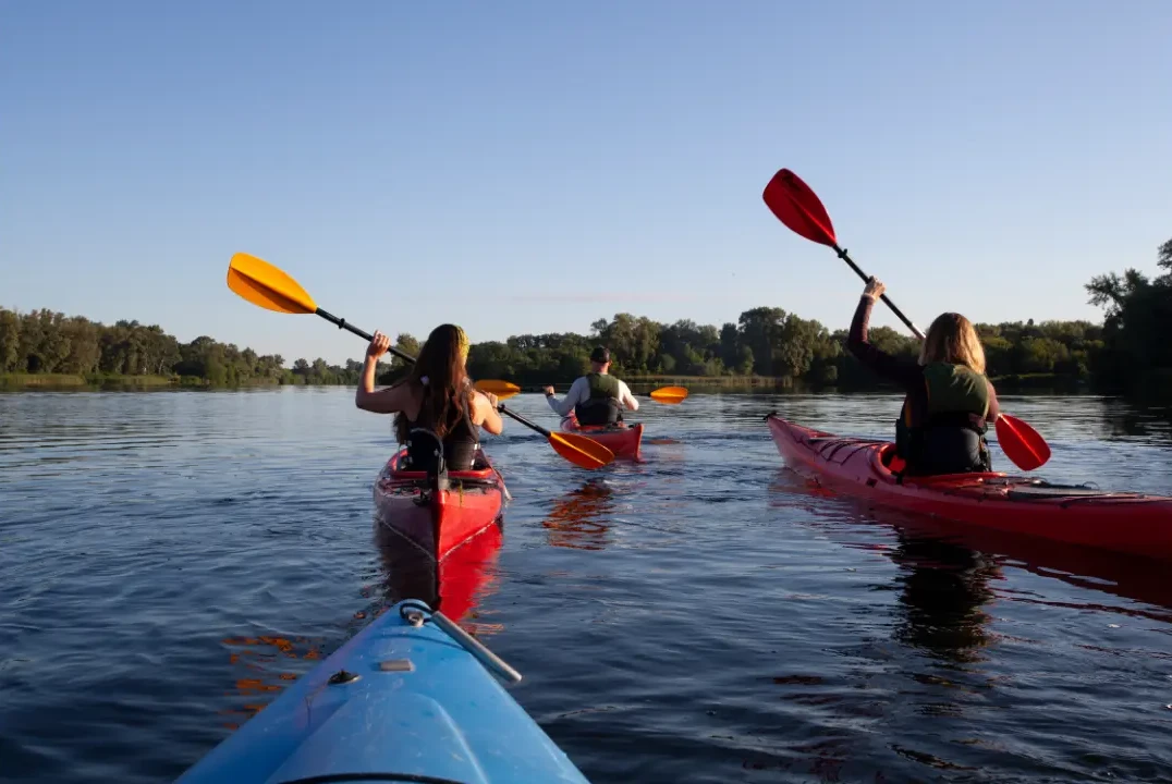 A group of people kayaking at the lake.