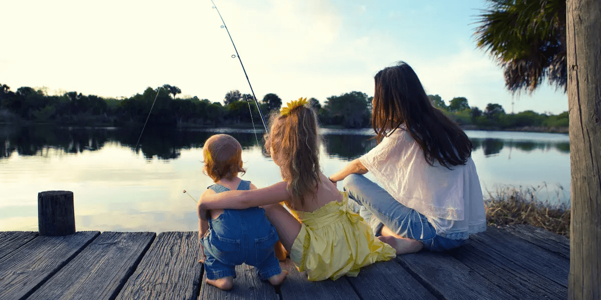 A woman with her two kids fishing on the dock